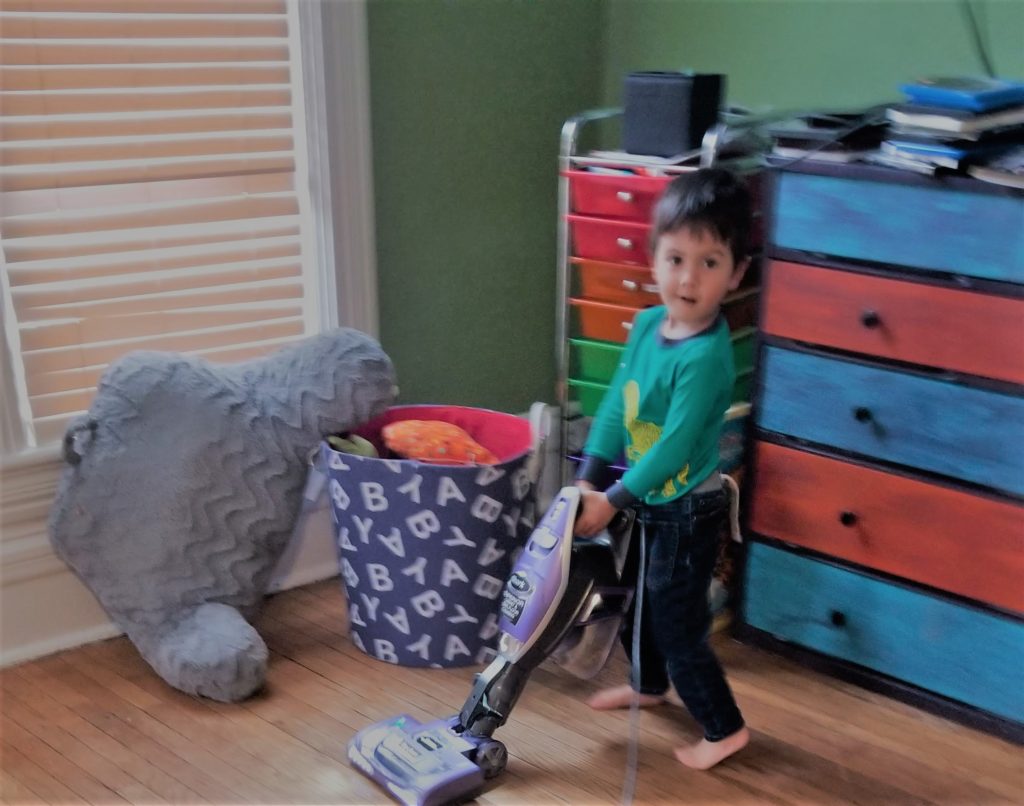 This kid loves vacuuming!